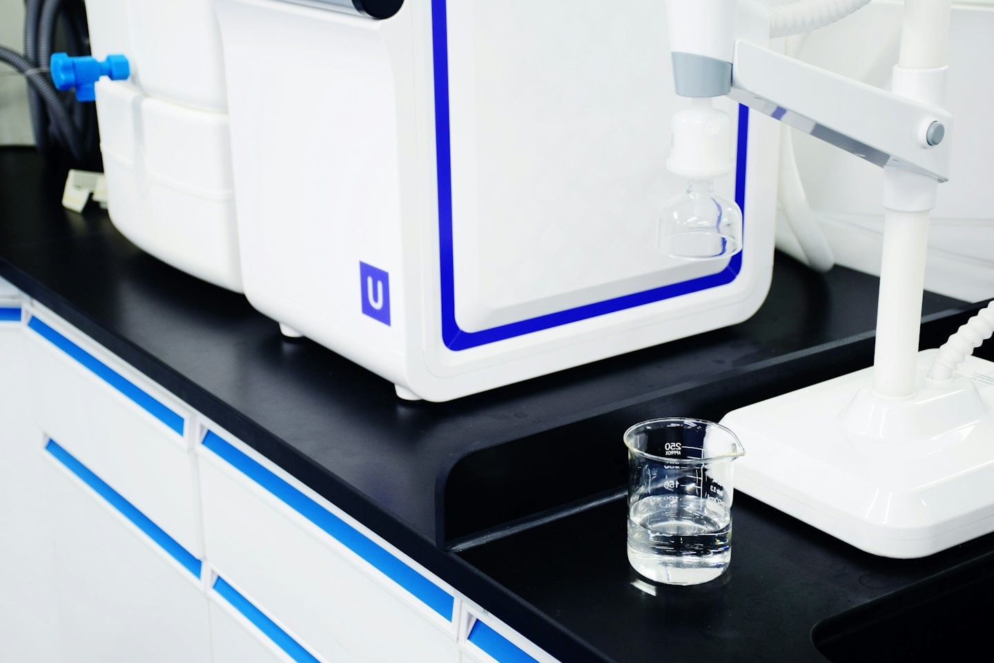 Modern water purification system with beaker on workbench.